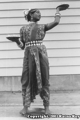 Shyamali standing on the narrow rim of a brass plate in the Thali dance.